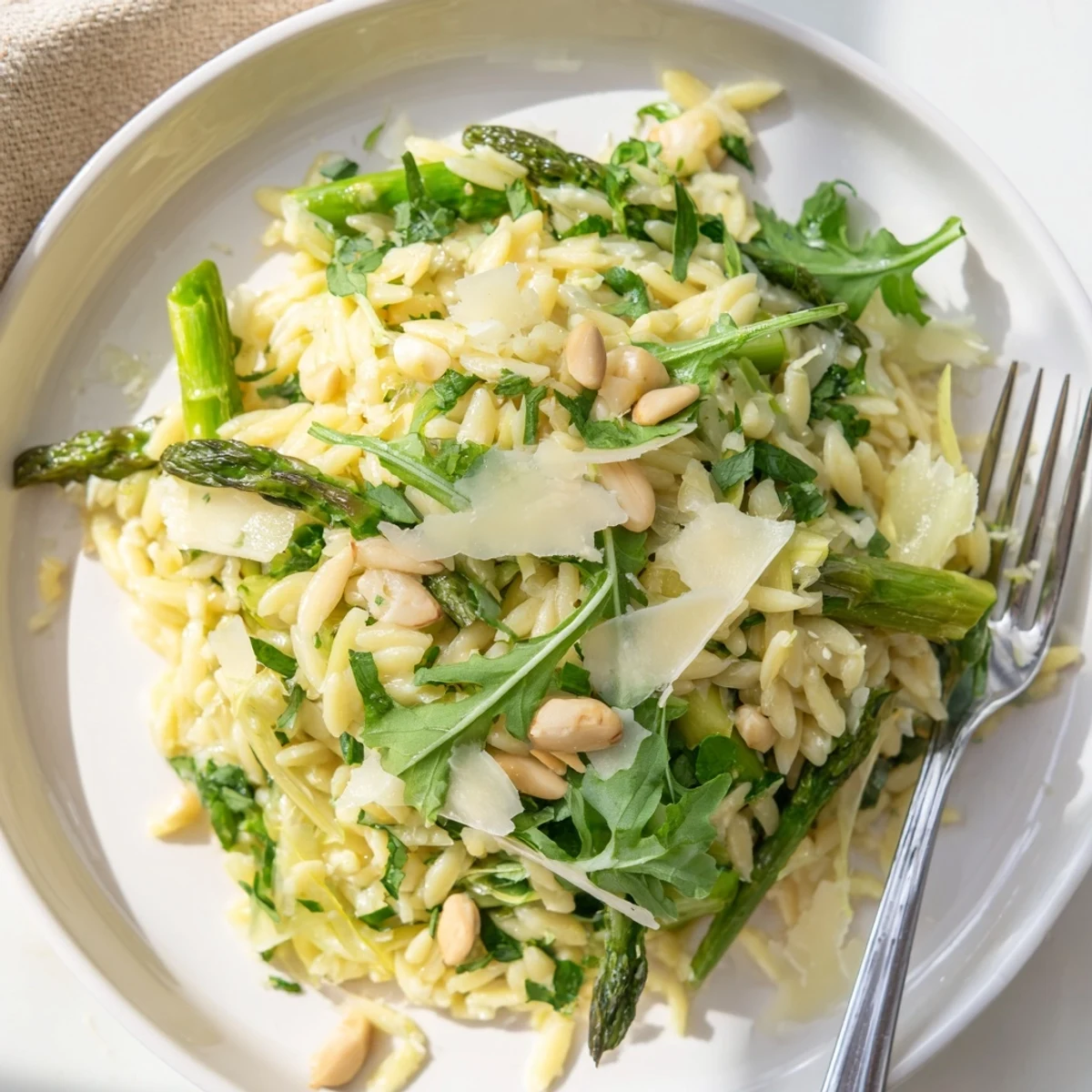 Shaved asparagus ribbons glisten alongside tender orzo in a vibrant Asparagus Lemon Orzo Salad, topped with grated Parmesan and toasted pine nuts.