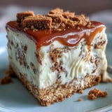 A slice of Decadent Baked Biscoff Cake with Creamy Lotus Frosting reveals a tender vanilla sponge swirled with crunchy Biscoff biscuit pieces.