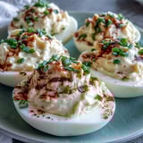 Creamy Million Dollar Deviled Eggs served chilled on a white platter, extra chives and paprika highlighting the smooth, flavorful filling.