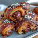 Golden mini pigs in a blanket with flaky pastry and juicy cocktail sausages, served with tangy honey mustard dipping sauce.