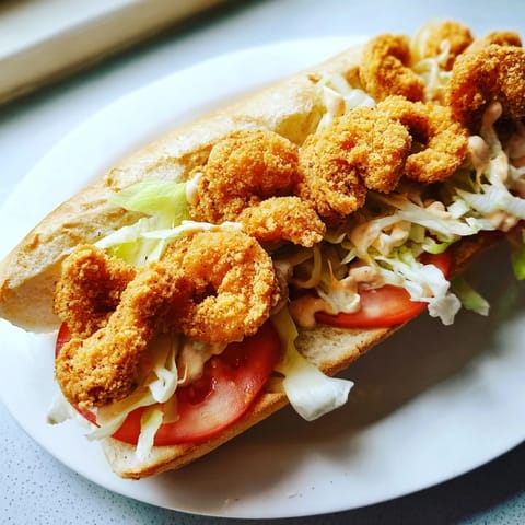 Golden-brown fried shrimp loaded into a classic Shrimp Po Boy sandwich with fresh, crisp lettuce.