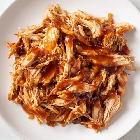 Slow-cooked BBQ pulled chicken, flavorful and easy to shred with forks, perfect for sandwiches or bowls.