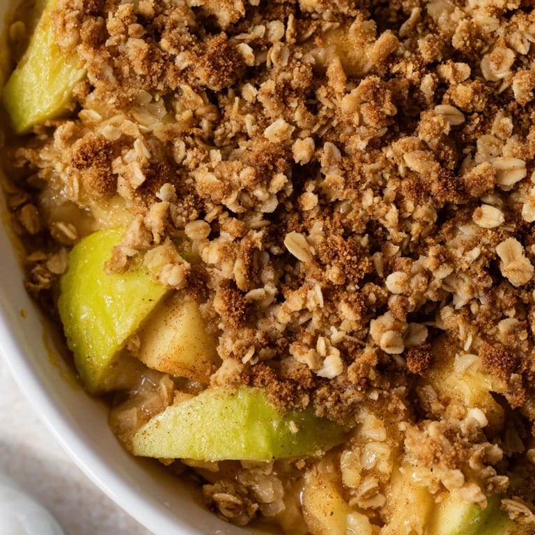 Buttery, crumbly topping melting over spiced apples; a classic Apple Crumble dessert.