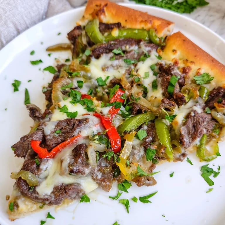 Golden Philly Cheesesteak Pizza featuring savory steak, peppers, onions, and melted cheese, perfect for dinner.