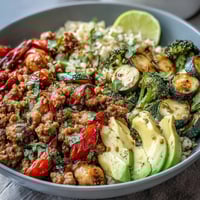 Roasted vegetables, seasoned ground turkey, and fluffy brown rice come together in this vibrant Ground Turkey Bowl, topped with fresh cilantro and avocado slices for a wholesome meal.  