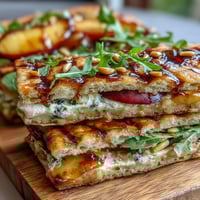 BBQ Peach and Brie Flatbread on the Grill with golden peaches and melty cheese, served on a wooden board.